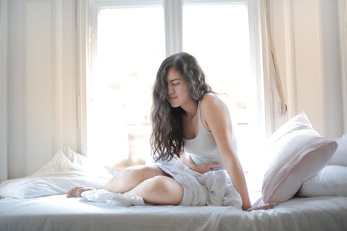 Woman feeling dizzy after turning over in bed